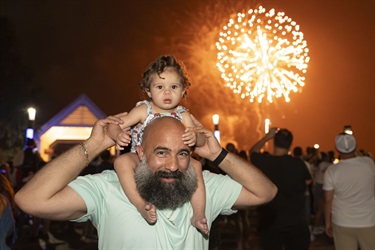 Father and daughter watching fireworks at Monumental 4th of July in Kissimmee. 